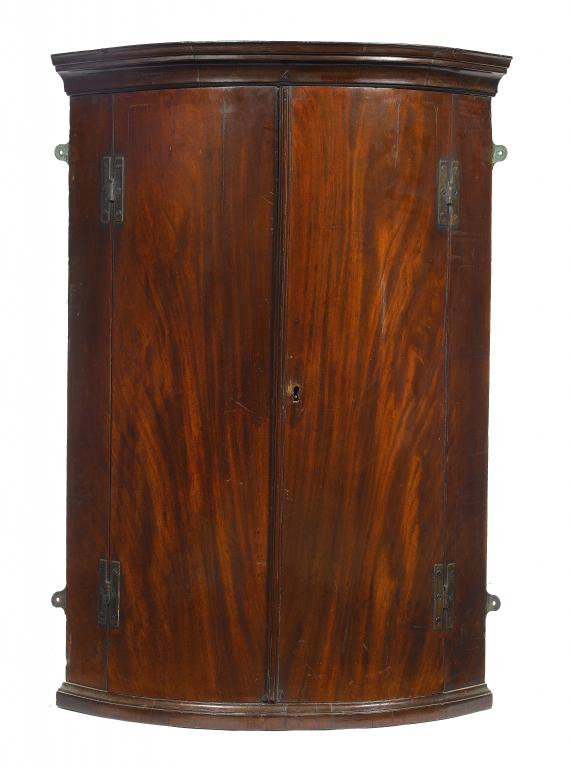 Appraisal: A GEORGE III MAHOGANY BOW FRONTED CORNER CUPBOARD with cavetto