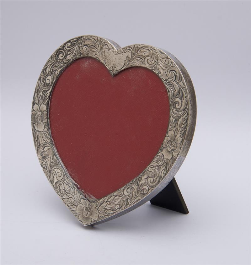 Appraisal: LEBKUECHER CO ENGRAVED SILVER HEART-SHAPE PICTURE FRAME With black plastic