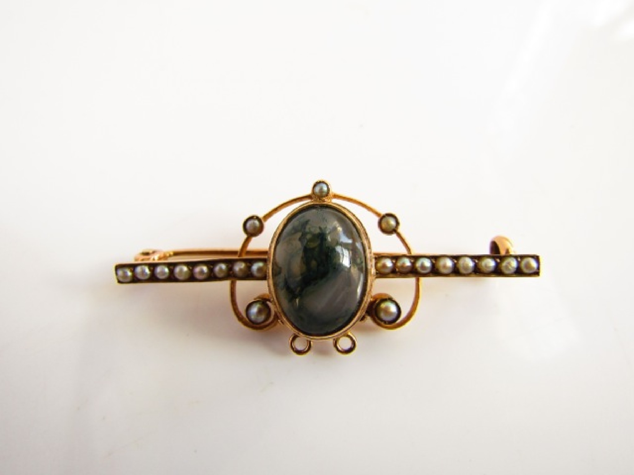 Appraisal: An Edwardian style bar brooch centred with an oval cabochon