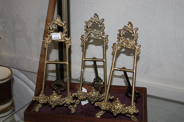 Appraisal: THREE GILT METAL EASEL PLATE STANDS and a malacca and