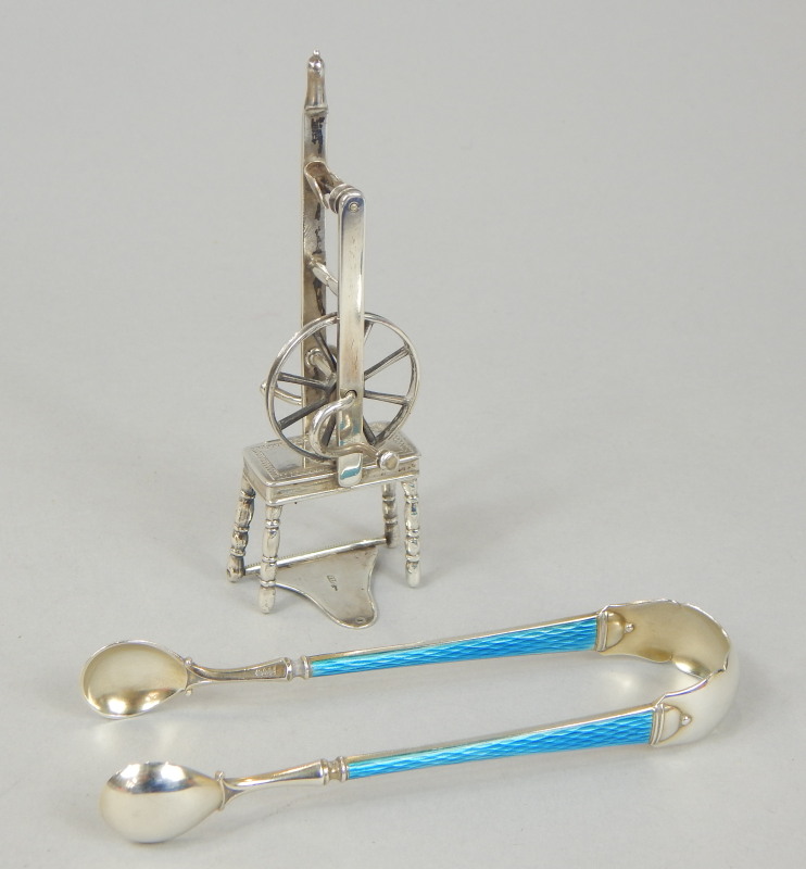 Appraisal: A pair of sugar tongs with blue enamel handles white