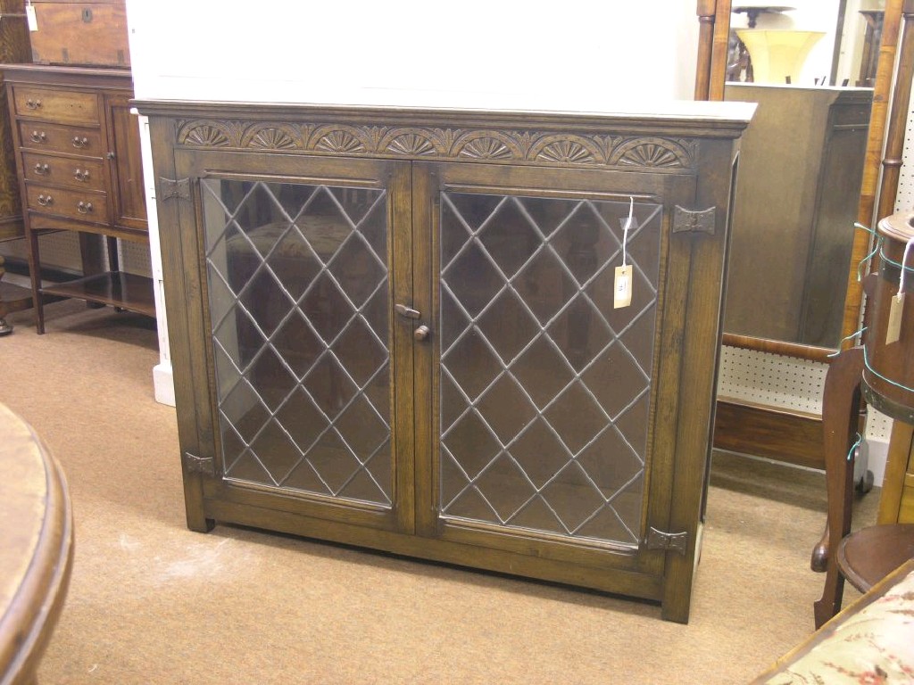 Appraisal: A reproduction dark oak bookcase lunette rail above a pair