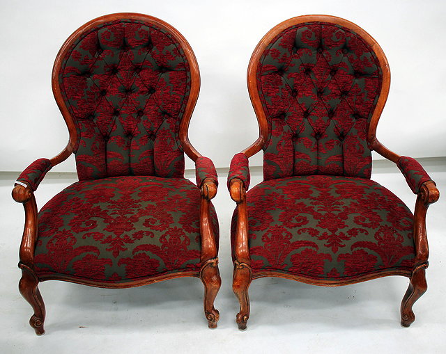 Appraisal: A PAIR OF BUTTON UPHOLSTERED OPEN ARMCHAIRS with scrolling arms