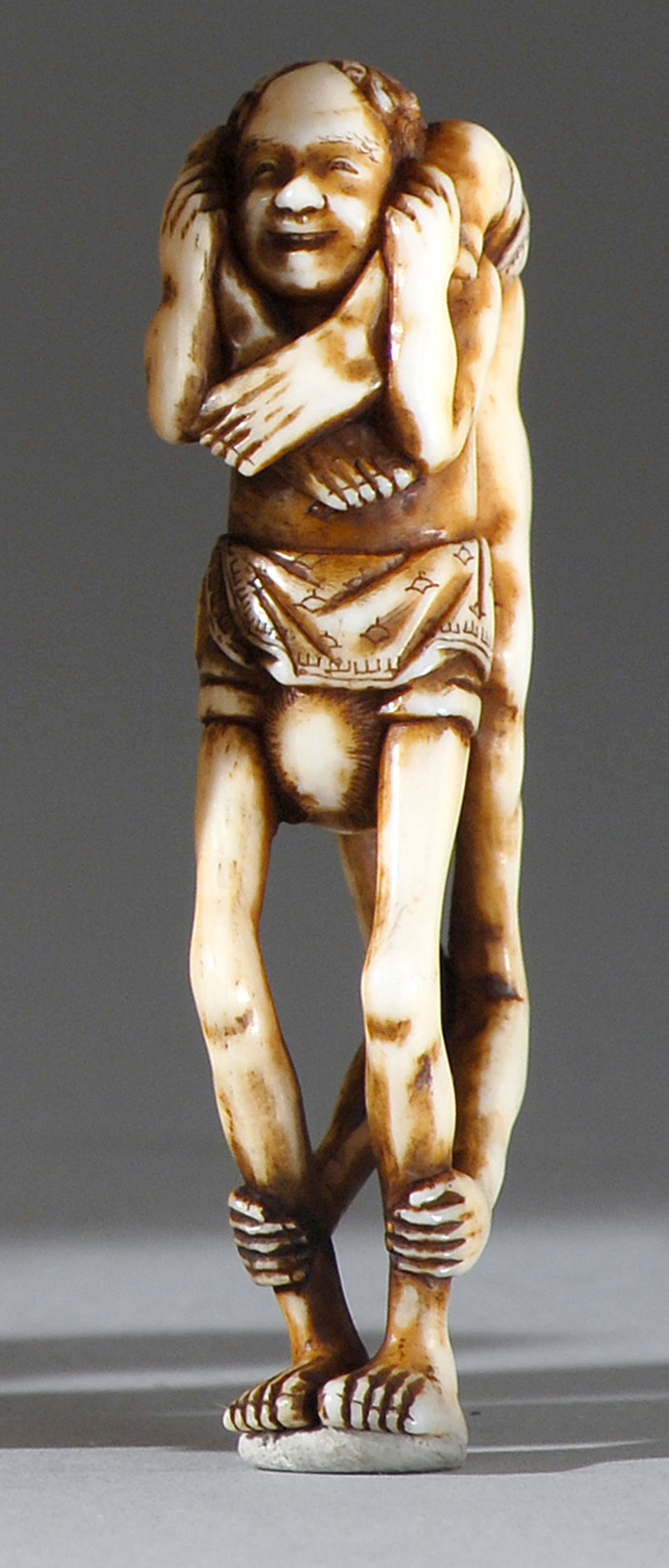 Appraisal: IVORY NETSUKE th CenturyDepicting an ashinaga and a tenaga in