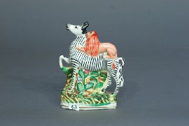 Appraisal: A Staffordshire figure of a zebra being attacked by a