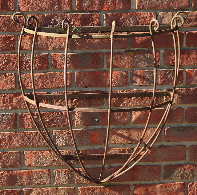 Appraisal: A WROUGHT IRON WALL MOUNTED HALF ROUND MANGER or basket