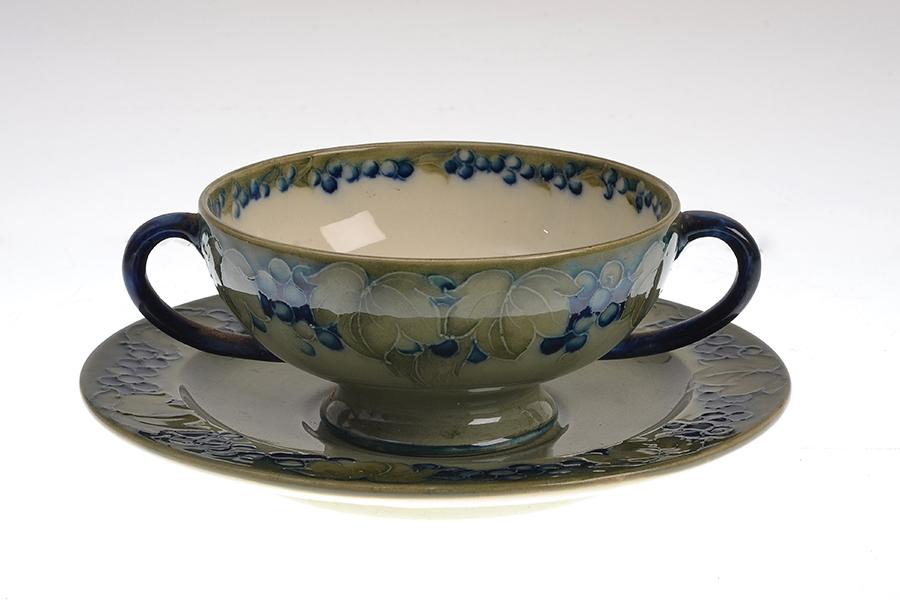 Appraisal: A MOORCROFT LEAF AND BERRY PATTERN CUP AND SAUCER leaf