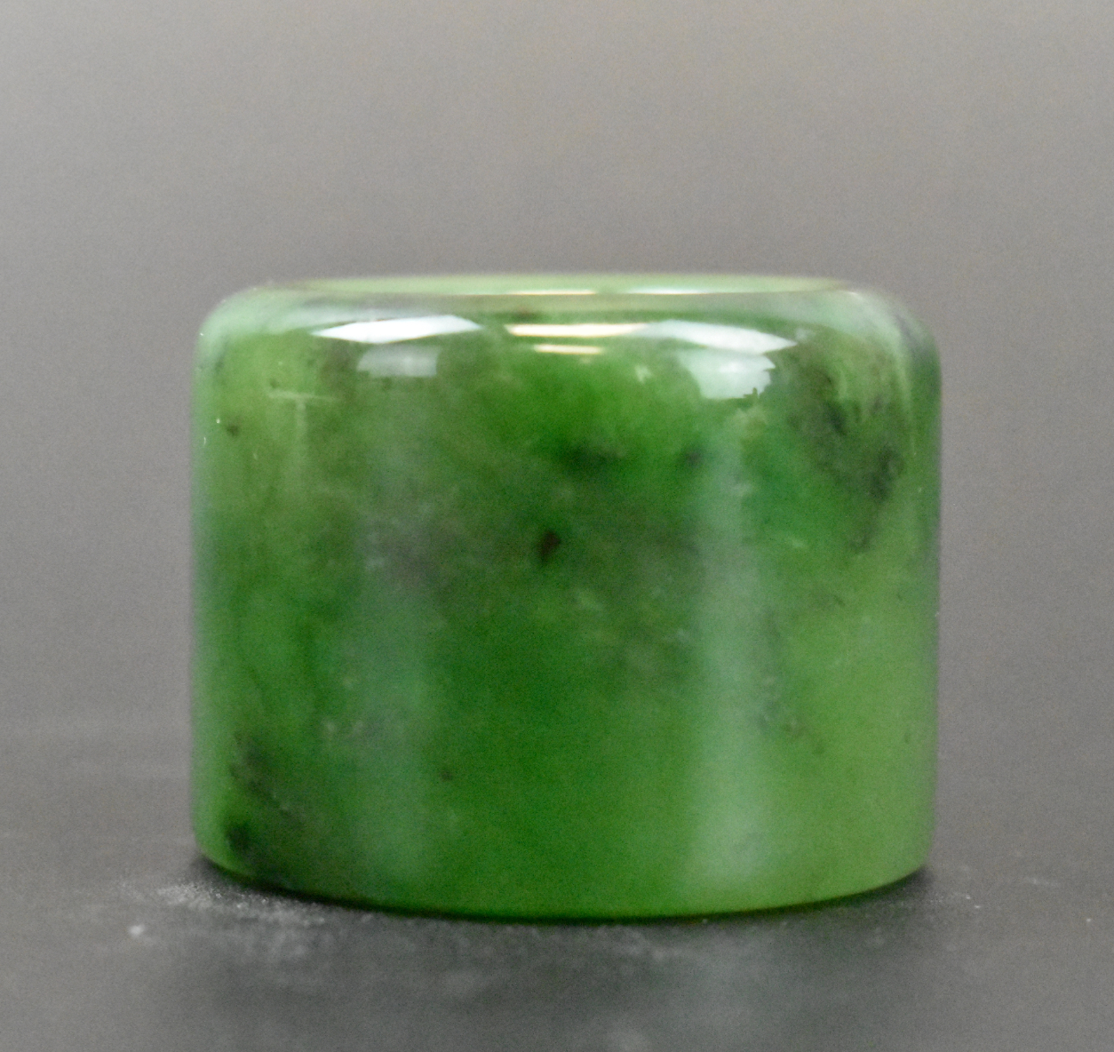 Appraisal: A spinach jade carved archer ring dating from the Qing