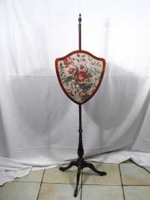 Appraisal: A mahogany fire screen with tapestry panelled shield on tripod