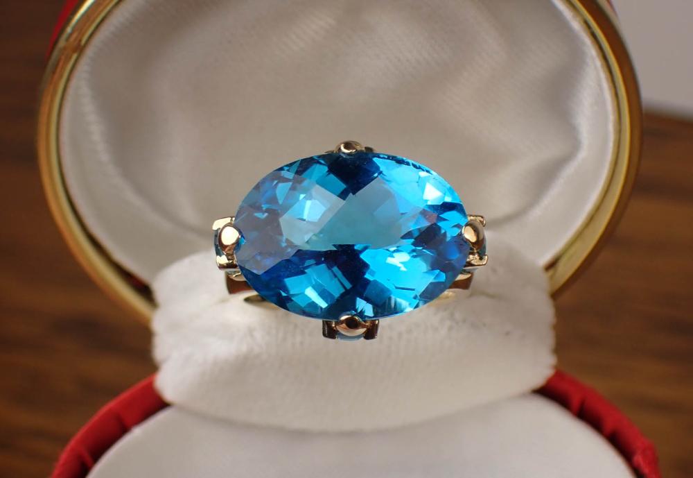 Appraisal: BLUE TOPAZ AND FOURTEEN KARAT GOLD RING with four oval-cut