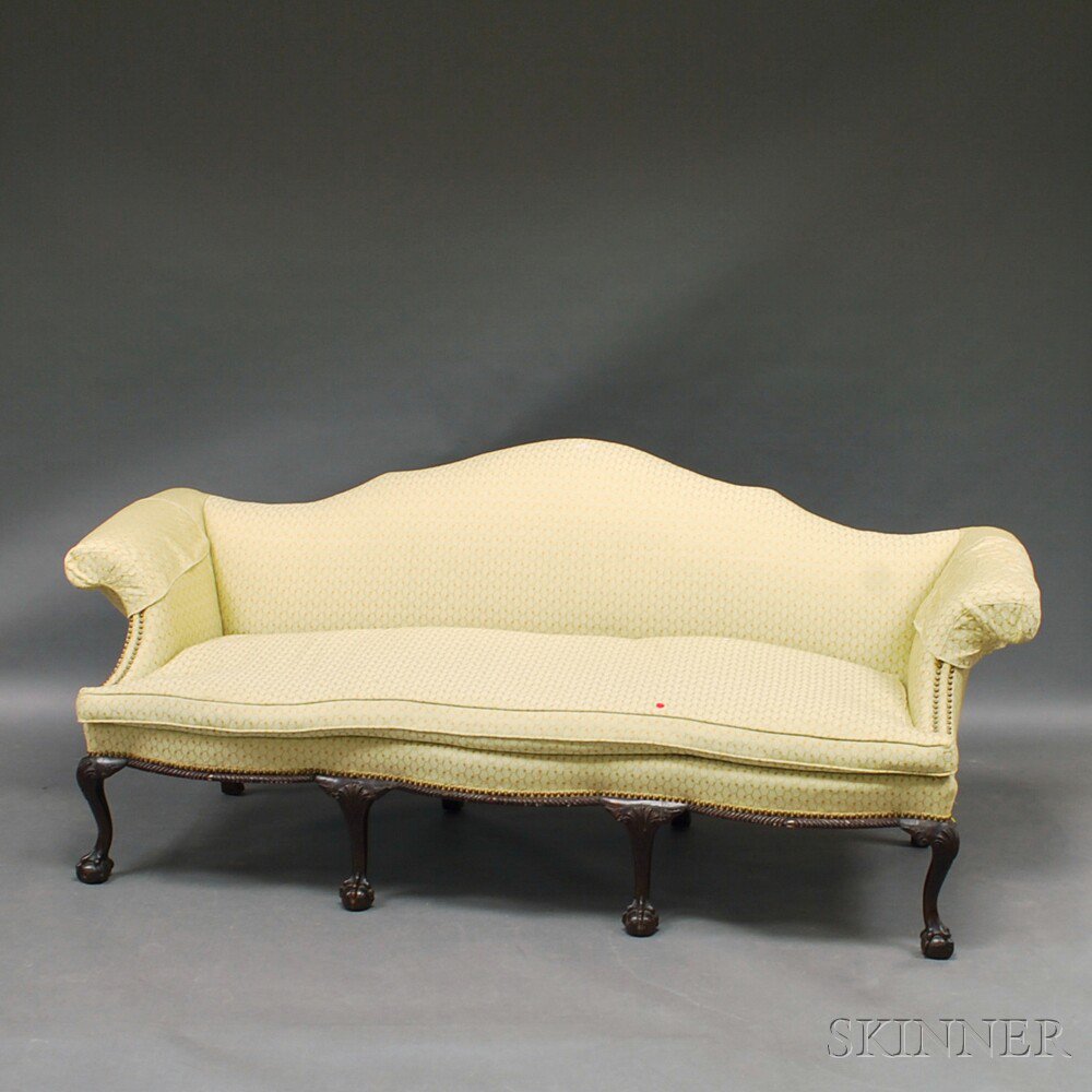 Appraisal: Chippendale-style Mahogany Camel-back Sofa in beige upholstery with gadrooning and