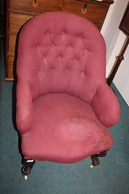 Appraisal: A VICTORIAN BUTTON BACK ARMCHAIR on carved walnut cabriole forelegs