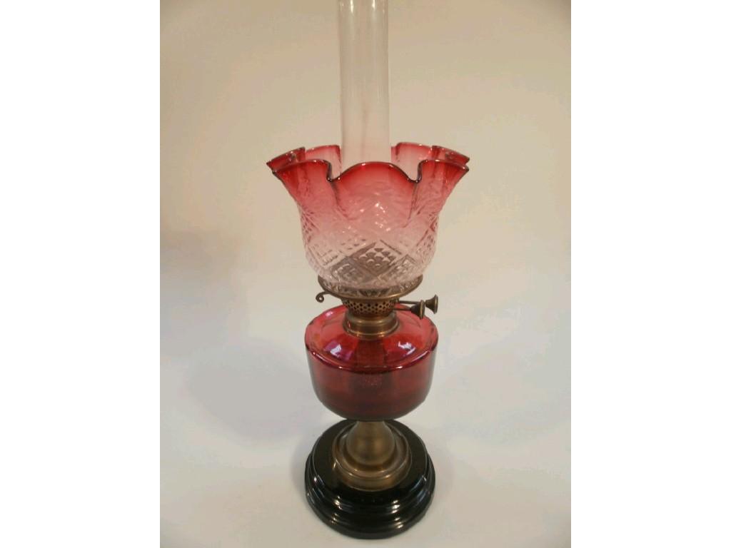 Appraisal: A Victorian oil lamp with Cranberry reservoir and Cranberry tinted