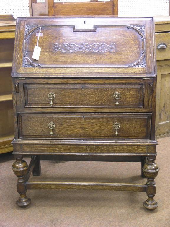 Appraisal: A Jacobean style solid dark oak bureau panelled fall front