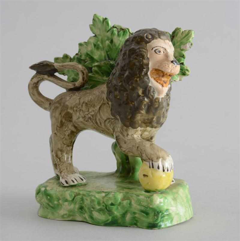 Appraisal: ENGLISH PEARLWARE FIGURE OF A LION With paw on yellow