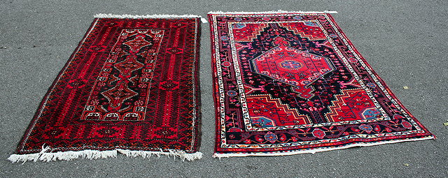 Appraisal: A MIDDLE EASTERN RED GROUND RUG with a banded border