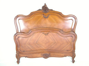 Appraisal: A French walnut double bed the arched panelled head and