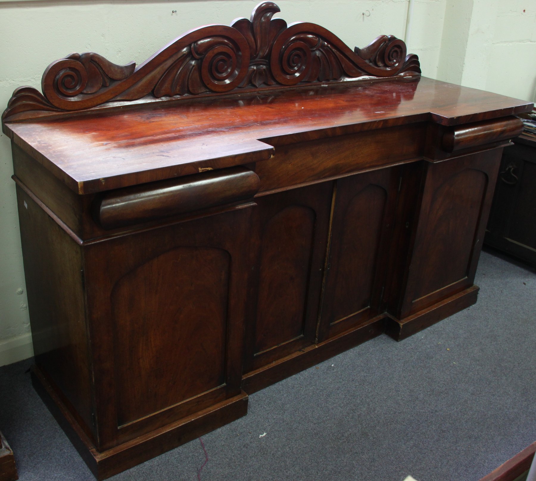 Appraisal: A Victorian mahogany breakfront sideboard the carved back above three