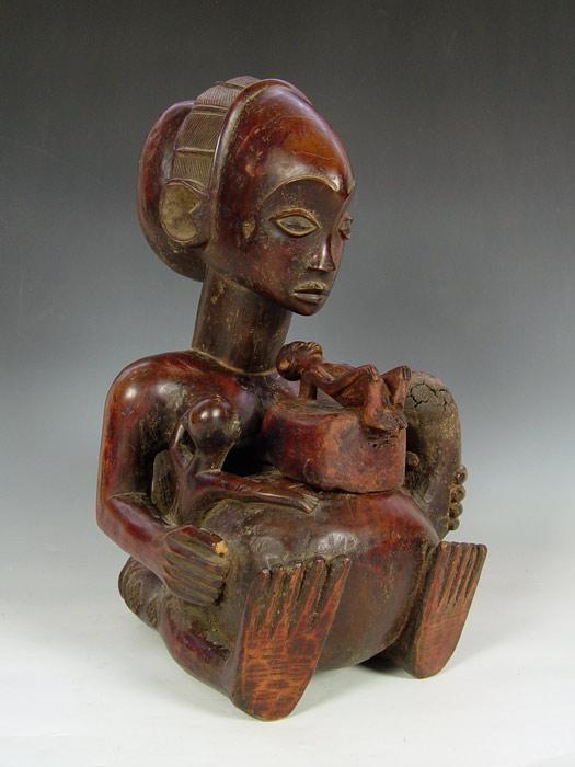 Appraisal: CARVED AFRICAN WOOD VESSEL MOTHER FEEDING Figural woman feeding one