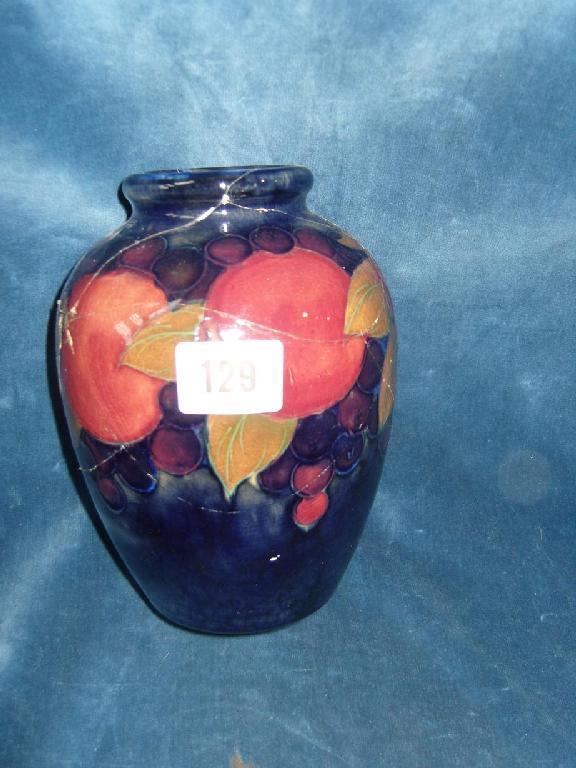 Appraisal: A blue ground Moorcroft vase with Pomegranate pattern decoration and