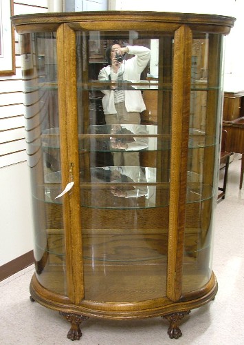 Appraisal: AN OAK AND CURVED GLASS CHINA CABINET American c with