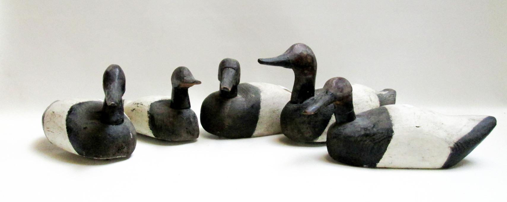 Appraisal: FIVE CARVED WOOD DUCK DECOYS the black and white painted