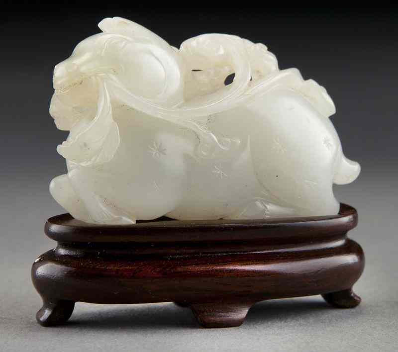 Appraisal: Chinese Qing carved white jade lamb holding a lingzhi in