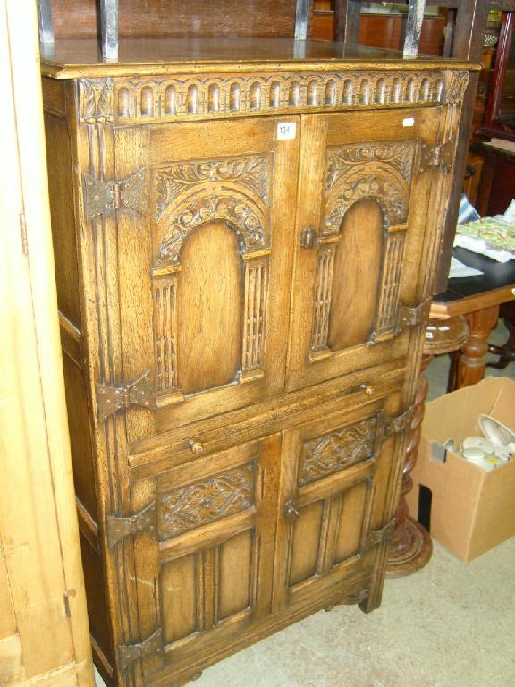 Appraisal: A reproduction oak side cupboard enclosed by four doors with