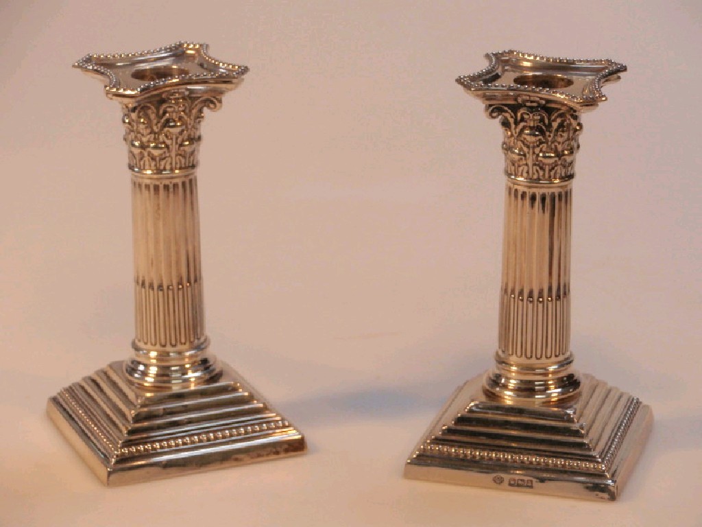 Appraisal: A pair of George V silver candlesticks of classical composite