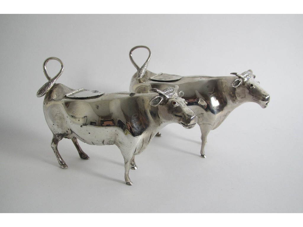 Appraisal: A matched pair of silver cow creamers each with curled