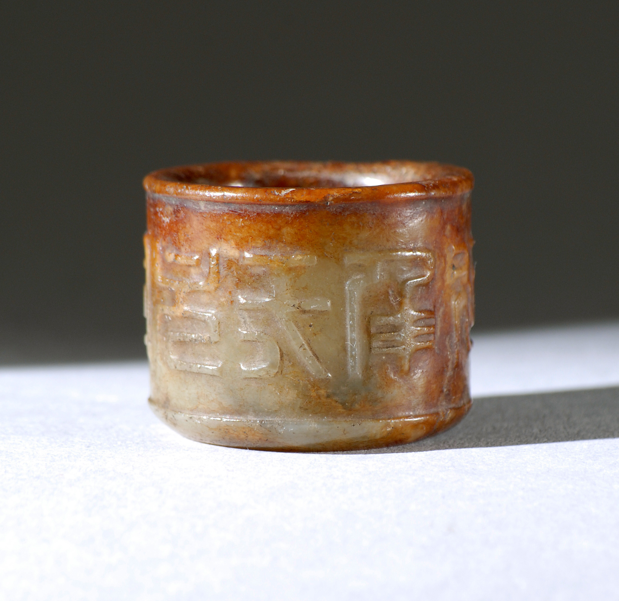 Appraisal: BROWN AND CELADON JADE SCHOLAR'S RING th CenturyWith raised seal-form