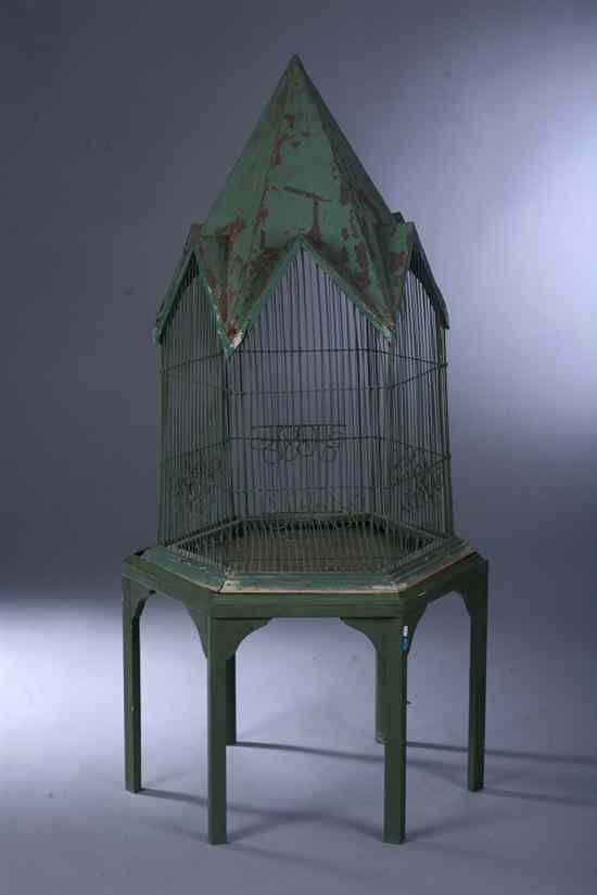 Appraisal: PARISIENNE GREEN-PAINTED T LE AND WIRE BIRDCAGE-ON-STAND Steepletop hexagonal-form cage