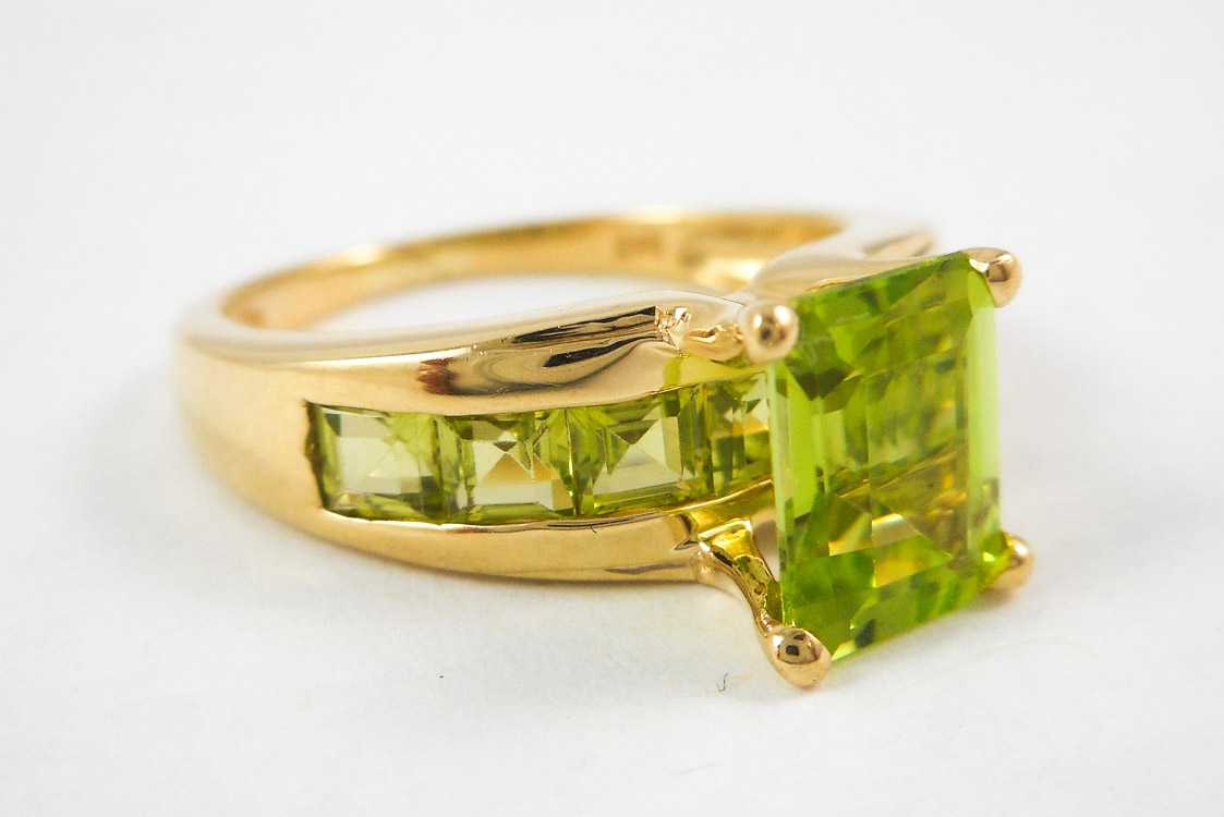 Appraisal: PERIDOT AND TEN KARAT YELLOW GOLD RING with seven table-cut