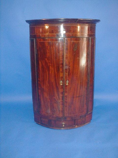 Appraisal: A George III flamed mahogany bow front hanging corner cupboard