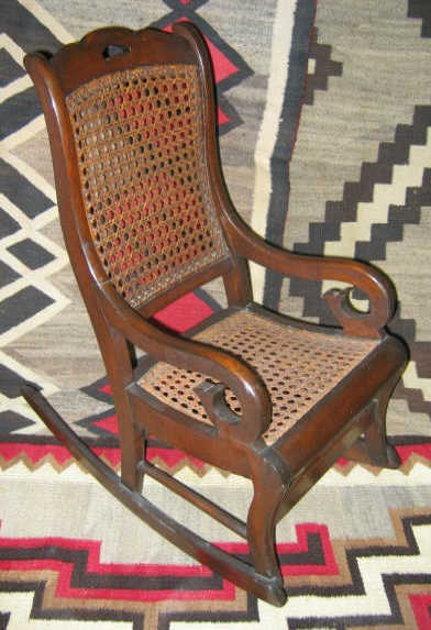 Appraisal: AMERICAN TH CENTURY WALNUT CHILD'S ROCKER Scrolling stiles flank the