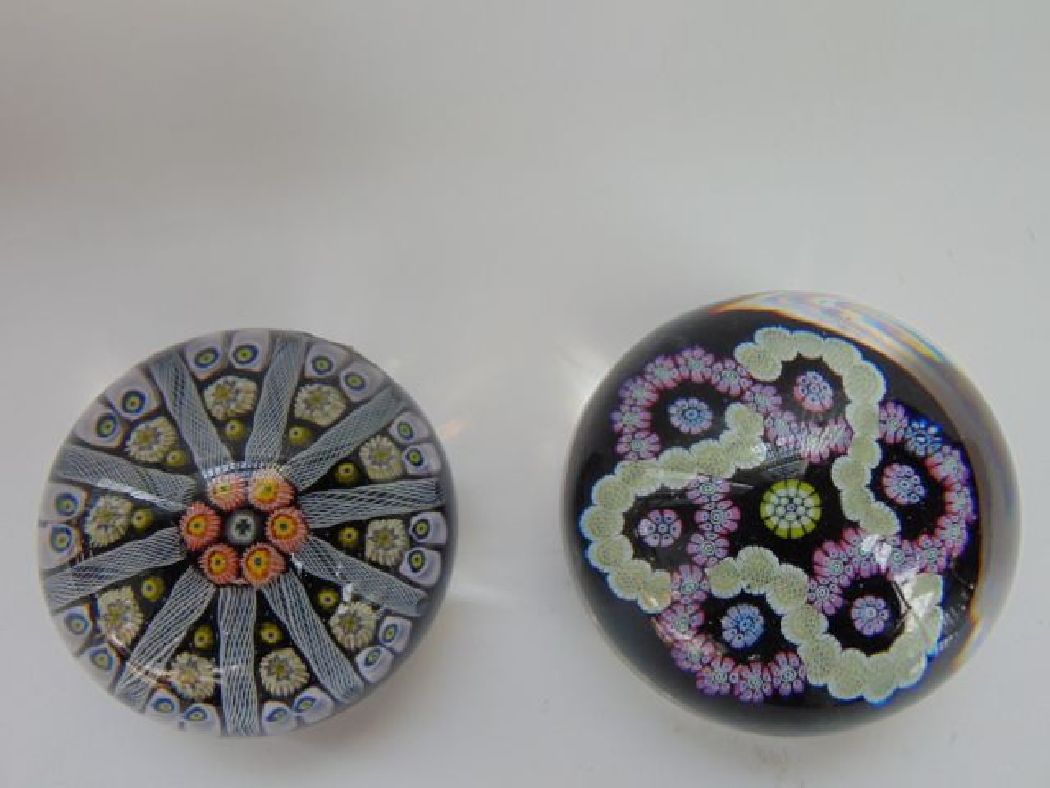 Appraisal: Two black ground millefiori glass paperweights one with interlinked pink