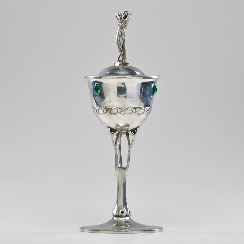 Appraisal: STYLE OF LIBERTY TUDRIC Lidded goblet with figural finial and