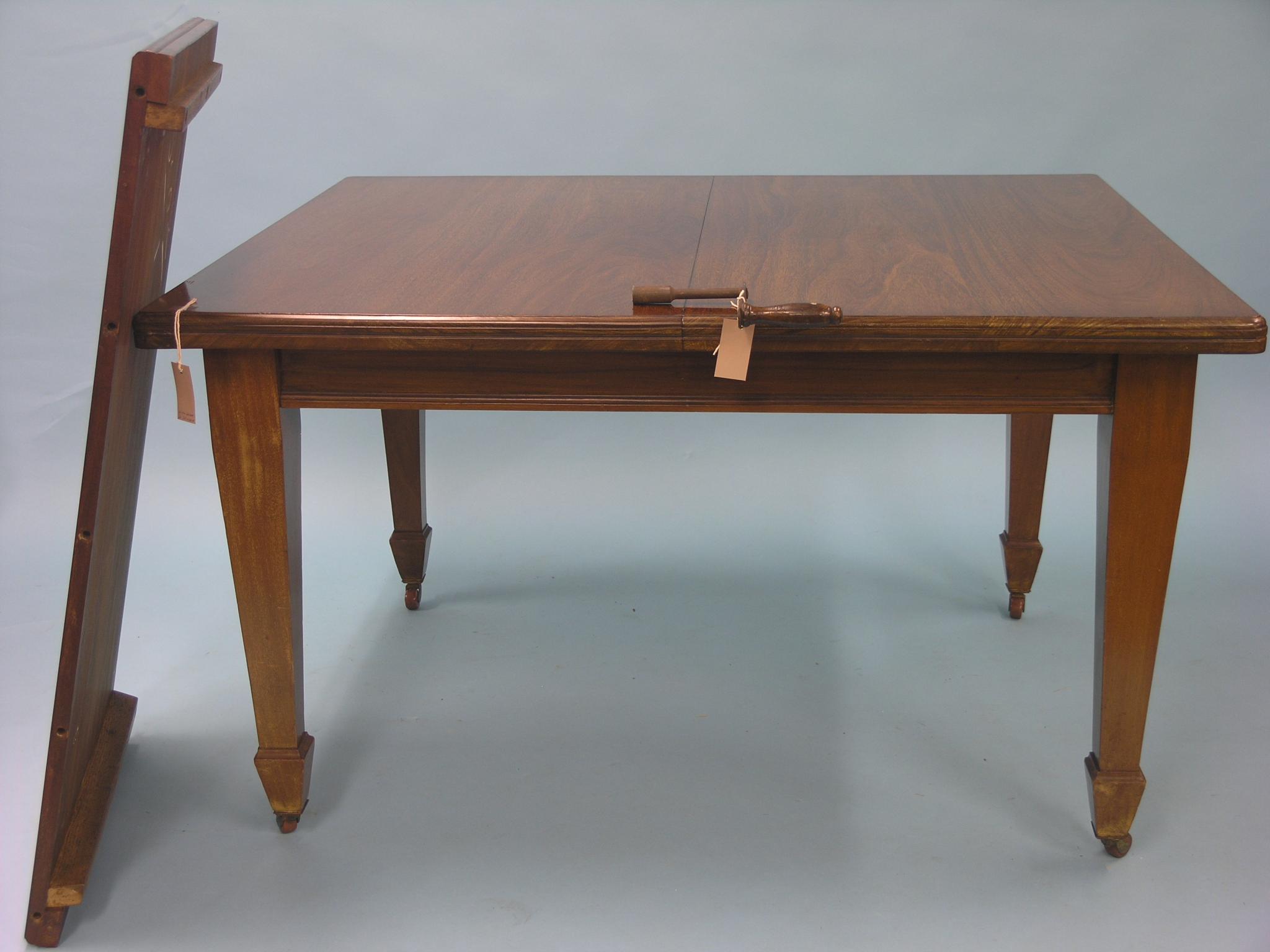 Appraisal: An early th century mahogany dining table wind-action with extra