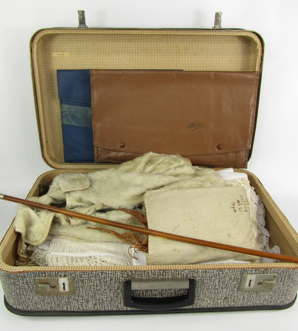 Appraisal: A suitcase of table linen and lace child's jacket from