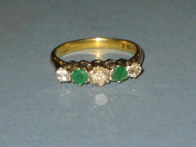 Appraisal: AN EMERALD AND DIAMOND FIVE STONE RING comprising two round