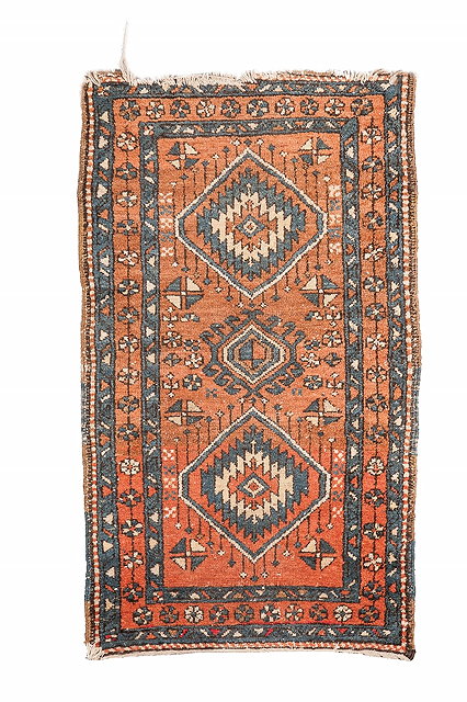 Appraisal: A HERIZ RUST GROUND RUG with triple diamond motif and