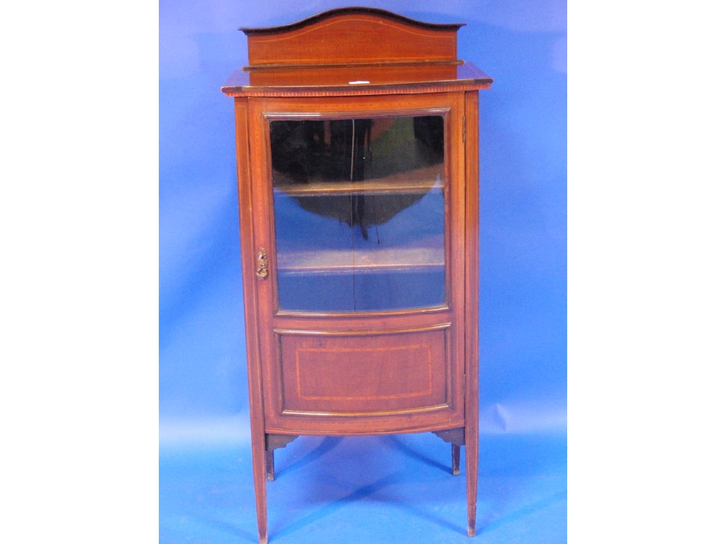 Appraisal: An Edwardian string inlaid mahogany bow front music cabinet