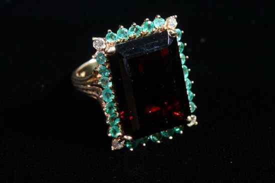 Appraisal: K YELLOW GOLD GARNET EMERALD AND DIAMOND RING Emerald-cut garnet