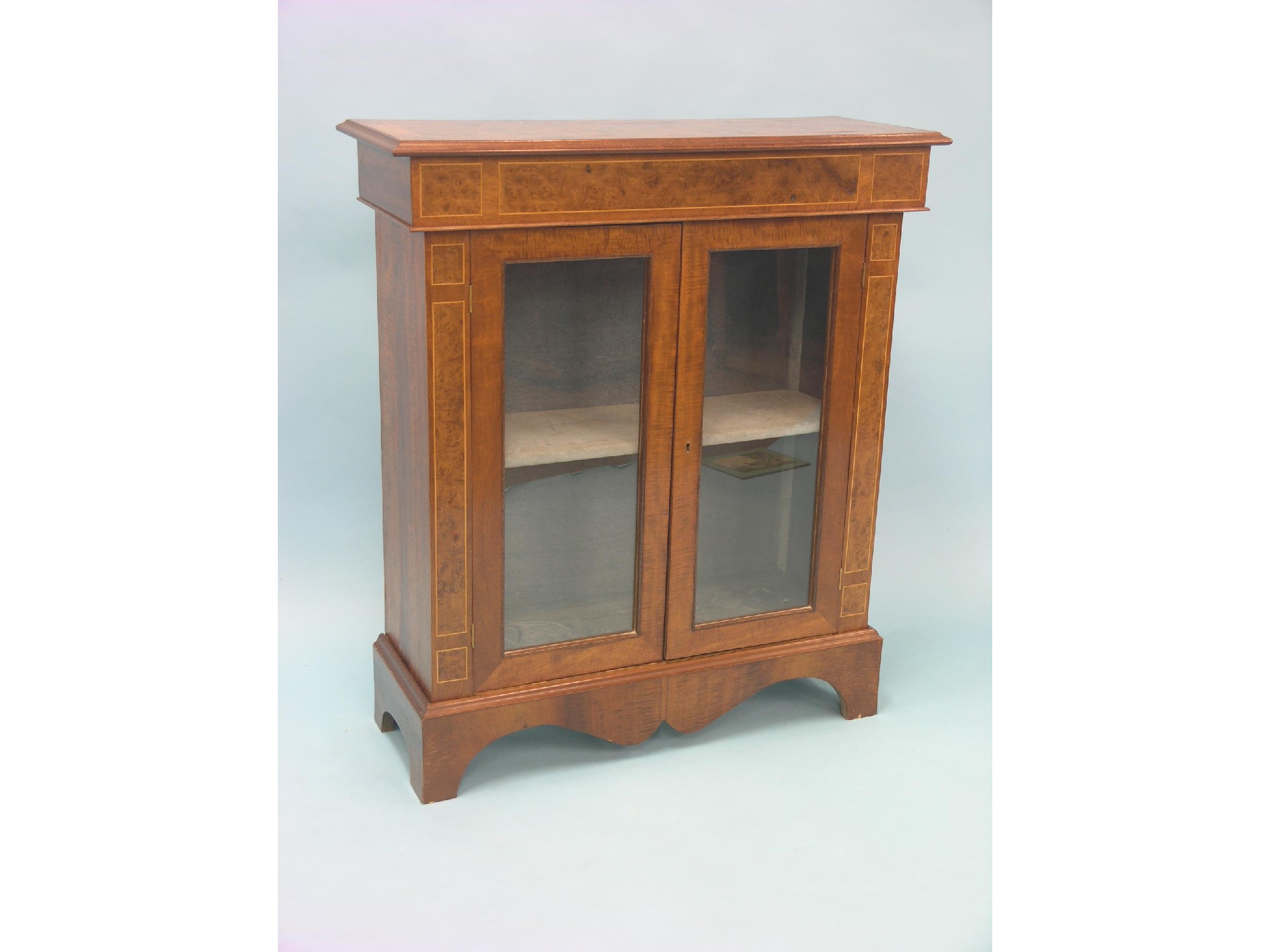 Appraisal: A reproduction burr elm display cabinet pair of glazed doors