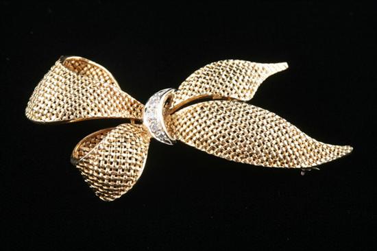 Appraisal: K YELLOW GOLD AND DIAMOND BOW PIN Diamond-set knot encircles