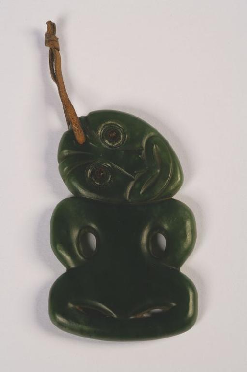 Appraisal: A MAORI GREEN NEPHRITE TIKI with carved and pierced features