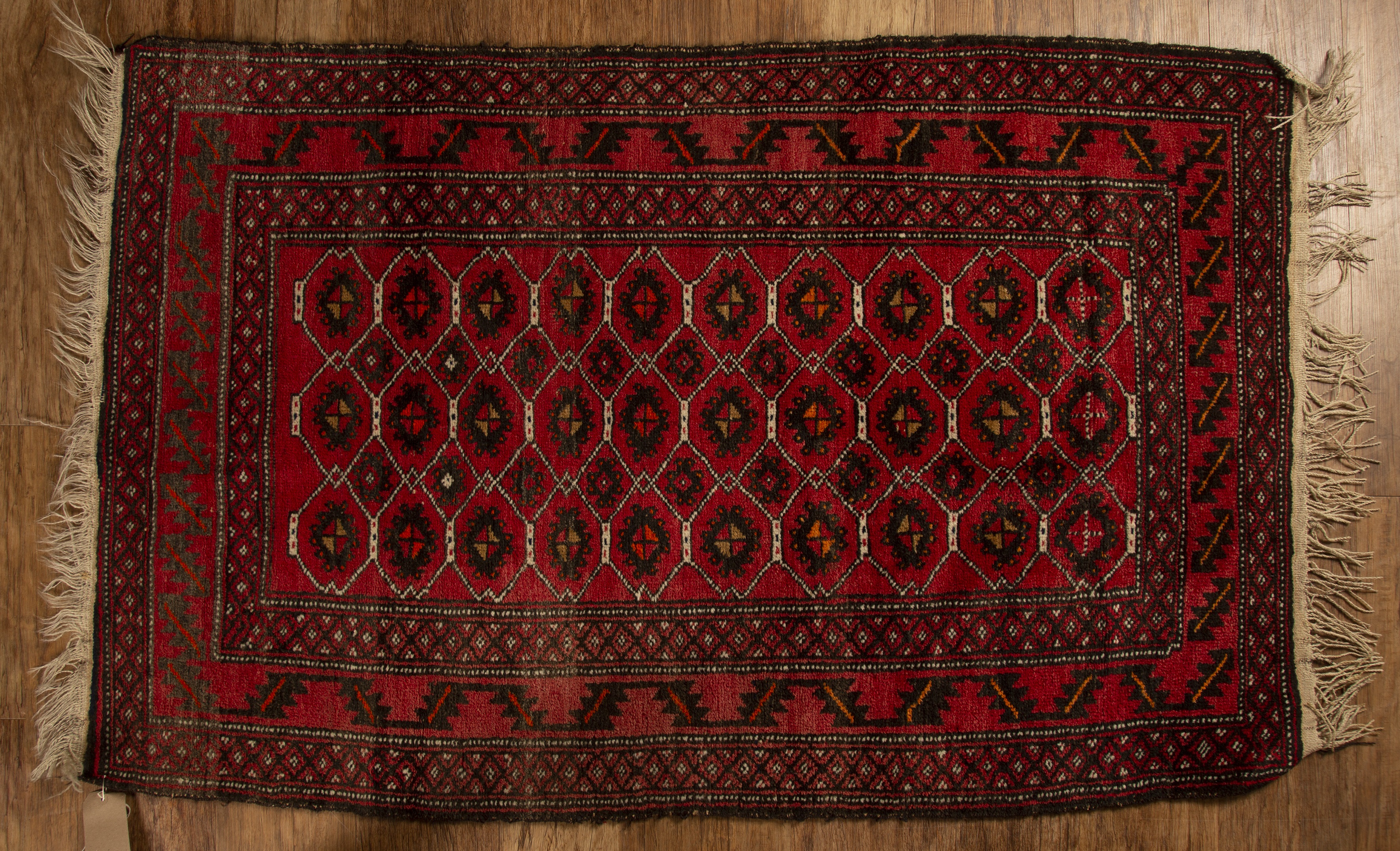 Appraisal: Red ground wool rug with geometric designs and stylised leaf