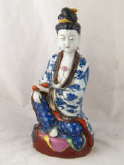 Appraisal: A ceramic figure of Buddha a scroll in her left