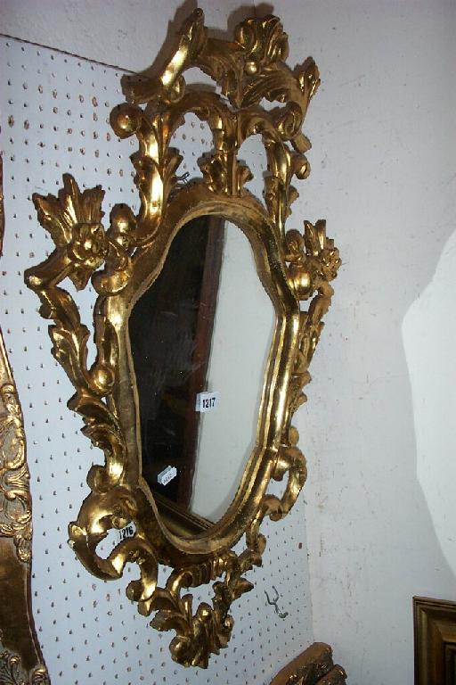 Appraisal: A carved and gilded Florentine frame with shield shaped mirror