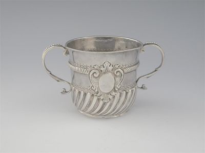 Appraisal: A William III porringer decorated with swirl fluting around the